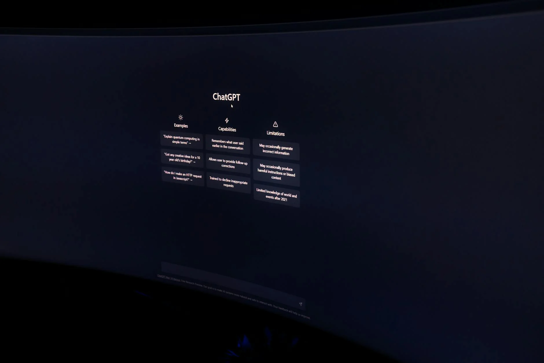 A dark, minimalist photo of a computer monitor displaying the ChatGPT interface.